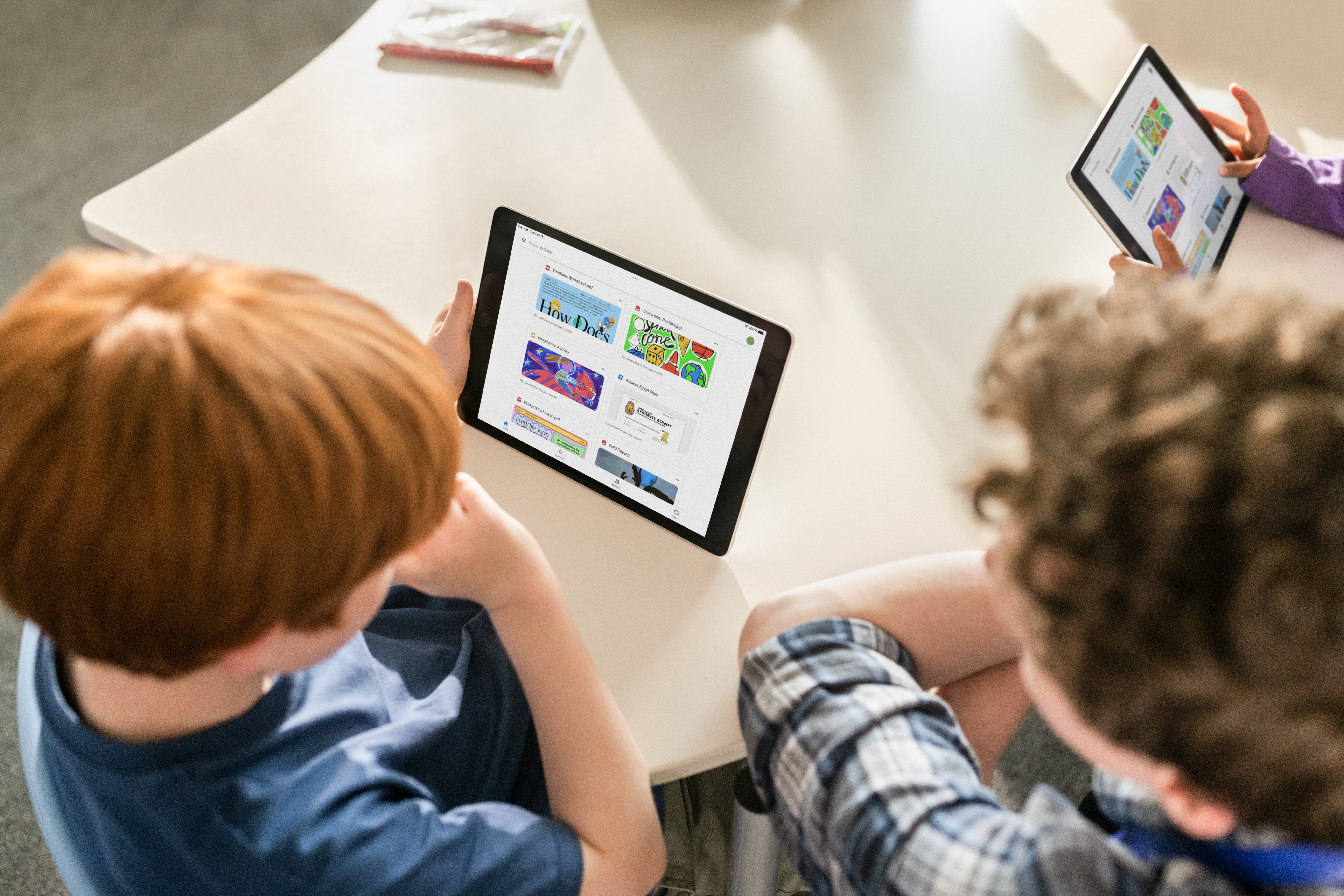 Ein Schüler und ein Lehrer sitzen im Unterricht vor einem iPad