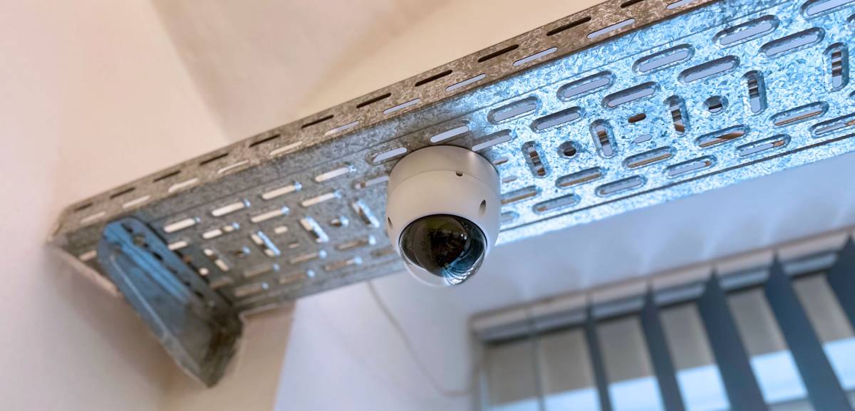 Die Kamera einer Alarmanlage, an einem Panel an der Decke montiert