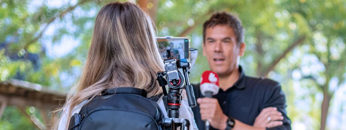 Tools at Work Bereichsleiter Video & Audio, Oliver Deutsch spricht in ein Mikrofon, im Vordergrund Claudia Söllner mit dem MobileMediaSet Rucksack